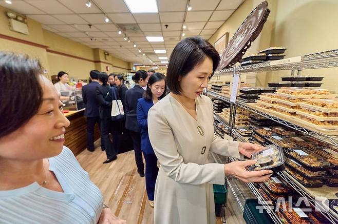 [뉴욕=뉴시스] 최동준 기자 = 김혜경 여사가 23일(현지 시간) 미국 뉴욕 코리아타운 한 마트를 방문해 김밥을 살펴보고 있다. (공동취재) 2025.09.25. photocdj@newsis.com