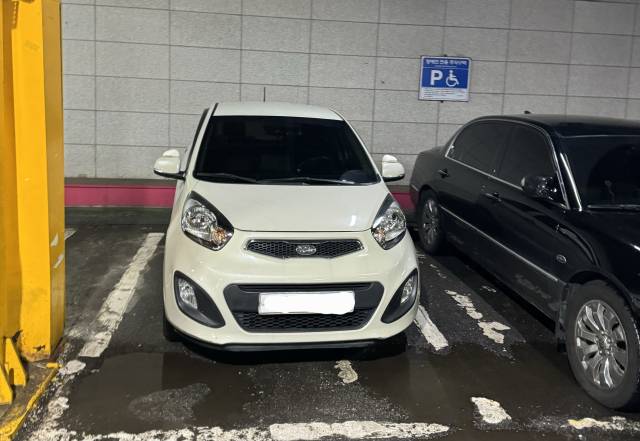 ▲전북 전주시 완산구 세이브존 1층 주차장. 25일 흰색 모닝 차량이 주차된 자리는 바닥 휠체어 그림이나 벽면 표지도 제거돼 장애인구역 표시가 전혀 없는 일반 주차면이지만 완산구청은 이곳을 '장애인주차구역 위반'으로 잘못 판단해 과태료를 부과했다가 취소한 사례가 있다. 양옆 자리만 장애인전용으로 지정돼 있다. ⓒ프레시안