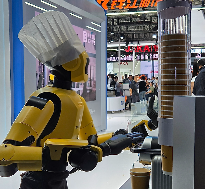 24일 중국 상하이 국제컨벤션센터에서 열린 ‘2025 로봇박람회’에서 중국 기업 ‘덱스포스’의 휴머노이드 로봇이 관람객에게 커피를 내리고 있다. 상하이 곽소영 기자
