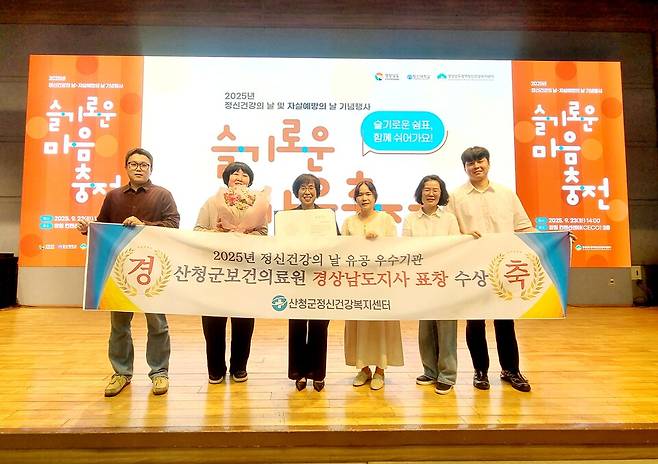 산청군정신건강복지센터 직원들이 창원컨벤션센터에서 열린 '2025년 정신건강의 날 기념식'에서 정신건강증진 유공기관 경남도지사 표창을 받고 기념촬영을 하고 있다. ⓒ산청군