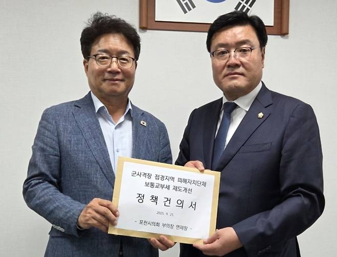 ▲ 연제창(오른쪽) 포천시의회 의원이 지난 25일 염태영 국회의원에게 군 사격장 접경지역 피해자치단체 보통교부세 제도개선을 촉구하는 건의서를 전달하고 있다./사진제공=포천시의회
