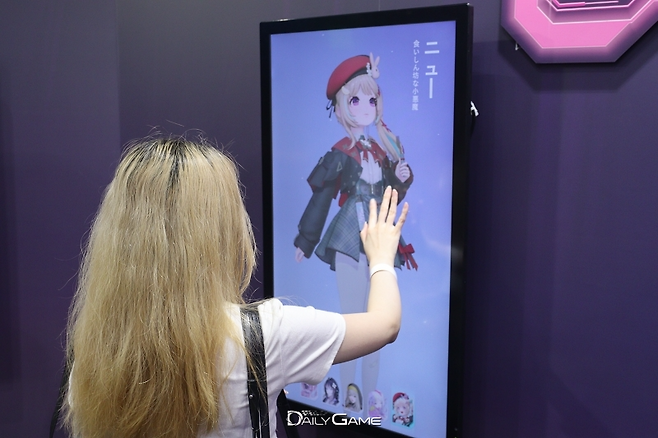 TGS 2025 스마일게이트 부스에 방문한 관람객이 '미래시' 캐릭터를 감상하는 모습.