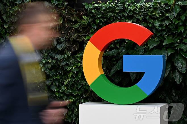 (FILES) A man walks past a Google logo at the Google Campus in Warsaw on February 13, 2025. ⓒ AFP=뉴스1