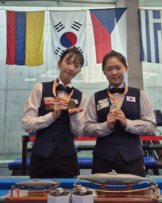 스페인 무르시아에서 25일 오후(현지시각) 열린 세계여자3쿠션선수권 시상식에서 준우승을 차지한 김하은(오른쪽)과 공동 3위에 오른 최봄이가 나란히 메달을 걸고 기념촬영을 하고 있다. 대한당구연맹 제공