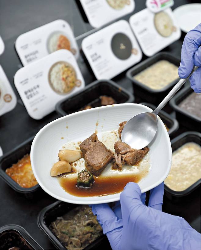 지난 18일 경기 성남시 현대그린푸드 스마트푸드센터에서 잇몸만으로도 먹을 수 있는 장조림을 숟가락으로 으깨며 부드러움 정도를 테스트하고 있다. 이 장조림은 음식 씹기에 어려움을 겪는 노인들을 위해 만든 고령 친화 식품 중 하나다. /고운호 기자