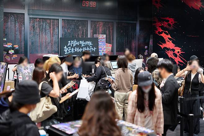 26일 서울 서대문구 현대백화점 신촌점 유플렉스에 마련된 카카오페이지 웹소설 '괴담에 떨어져도 출근을 해야 하는구나(괴담출근)' 팝업스토어 현장에 방문객들이 굿즈(상품)를 둘러보고 있다. [사진=카카오엔터테인먼트 제공]