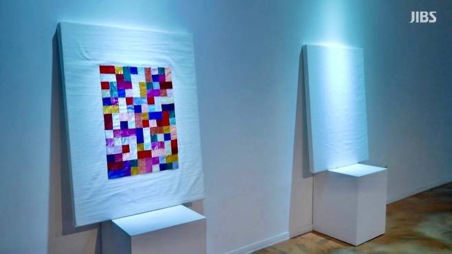 바늘땀이 모여 완성된 ‘아기 이불’. 조각보로 이어진 천이 전시장에 걸려 관람객을 맞이하고 있다.