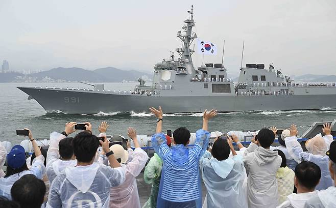 25일 부산 인근 해상에서 개최된 ‘2025 대한민국해군 관함식’에서 대형수송함 마라도함에 편승한 국민 참여단이 해군 함정들이 실시하는 해상사열을 관람하고 있다. [해군 제공]