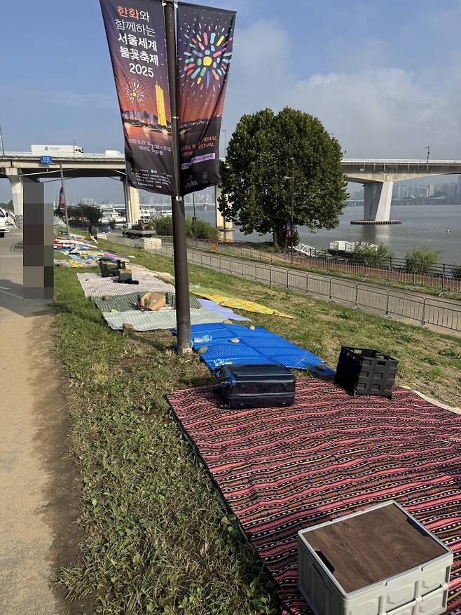 ‘2025 서울세계불꽃축제’를 하루 앞둔 26일 서울 영등포구 여의도한강공원 일대에 돗자리가 깔려 있다. 자료 : 온라인 커뮤니티