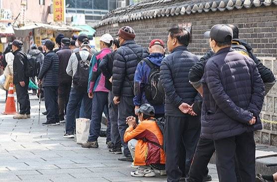 3월 24일 서울 종로구 탑골공원 인근 무료급식소 앞에 어르신들이 길게 줄을 서 식사 차례를 기다리고 있다. 뉴스1