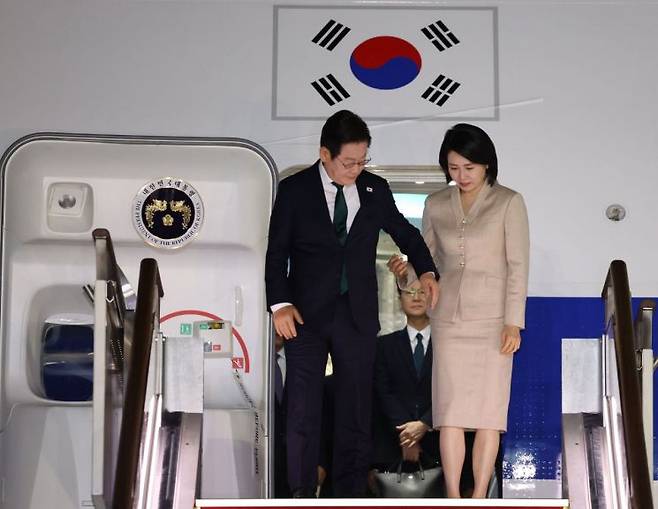미국 방문 일정을 마치고 귀국한 이재명 대통령과 김혜경 여사가 26일 성남 서울공항에 착륙한 공군 1호기에서 내리고 있다. 연합뉴스