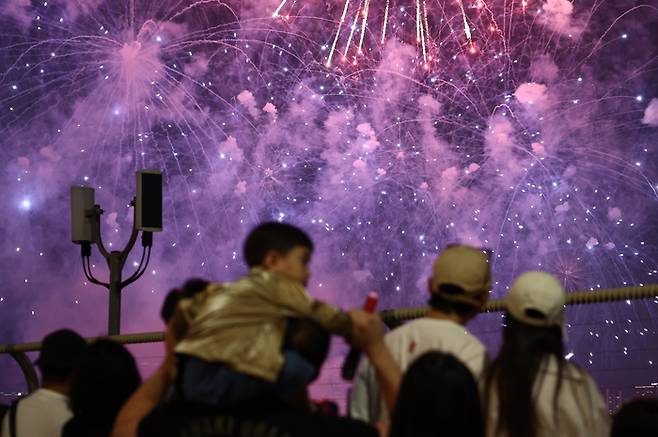 27일 서울 여의도 한강공원 일대에서 열린 ‘2025 서울세계불꽃축제’에서 시민들이 화려한 불꽃쇼를 보고 있다. 2025.9.27[뉴스1]