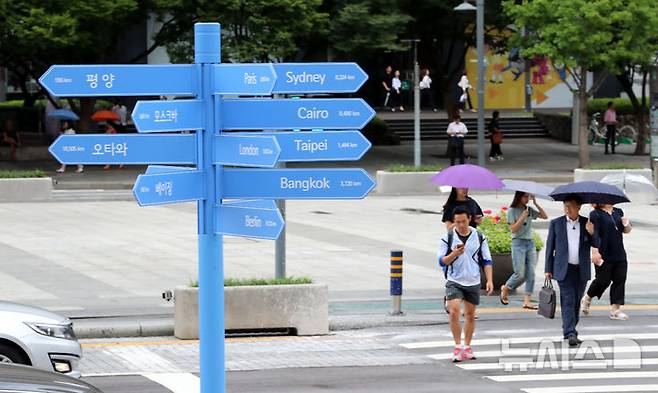 [서울=뉴시스] 박주성 기자 = 24일 오후 서울 세종문화회관 계단 앞에 평양을 비롯해 세계 15개 주요도시로 가는 방향과 거리가 적힌 파란색 기동의 '세계도시 이정표'가 설치되어 있다.  이정표가 자리하는 곳은 명동·이태원 등 외국인 관광객이 주로 찾는 보행밀집지역(10개소), 도심 속 자연을 느낄 수 있는 서울시내 주요 공원(5개소)과 한강공원(5개소)이다. 서울광장, 광화문, 동대문디자인플라자(DDP) 등 13개소는 이미 설치 완료했고, 나머지 7개소는 8월 말까지 설치한다. 2018.08.24. park7691@newsis.com