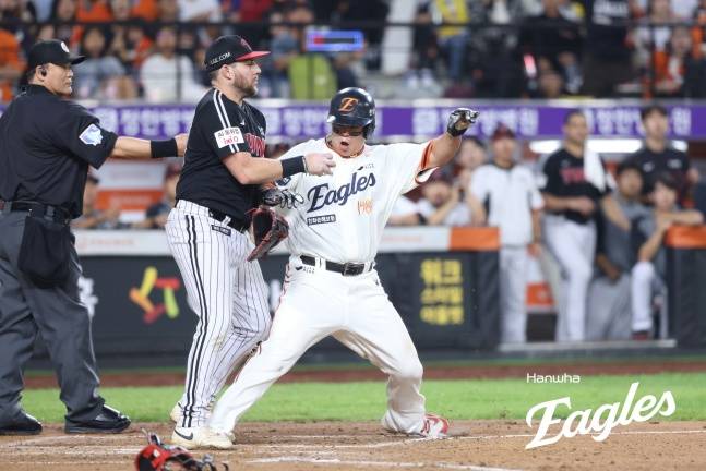 한화 노시환(오른쪽)이 26일 대전 LG전 7회말 1사 2, 3루에서 박동원의 태그를 피해 홈을 밟고 있다.