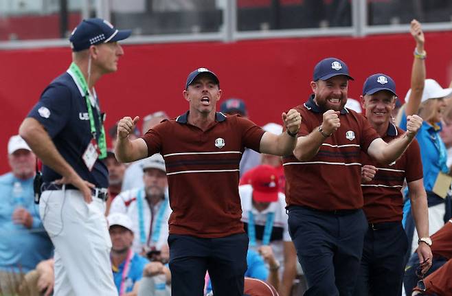 로리 매킬로이(왼쪽 두 번째)와 셰인 라우리(오른쪽 두 번째)가 팀동료 티럴 해턴이 18번홀에서 버디 퍼트를 넣어 승리를 확정하자 환호하며 기뻐하고 있다. (사진=AFPBBNews)