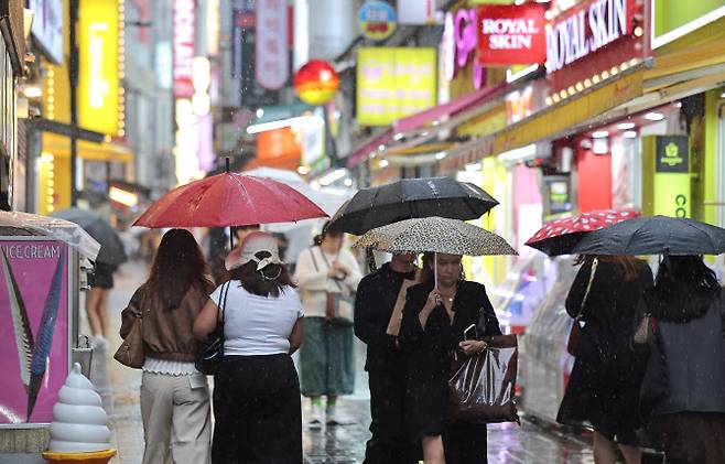 28일 비가 내리는 서울 중구 명동거리에서 시민 및 외국인관광객들이 우산을 쓴 채 걸어가고 있다. (사진=연합뉴스)