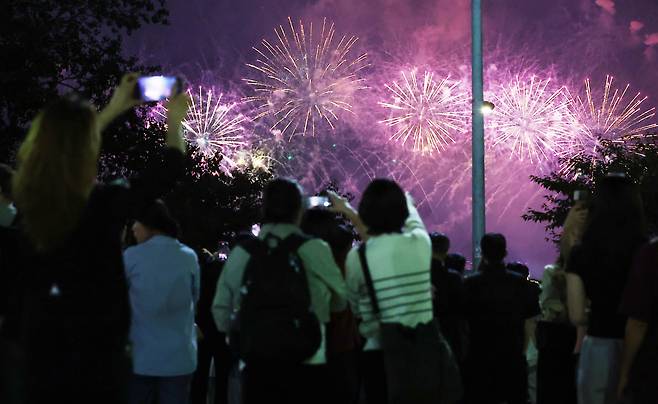 27일 서울 여의도 한강공원 일대에서 열린 '2025 서울세계불꽃축제'에서 시민들이 화려한 불꽃쇼를 보고 있다. /뉴스1