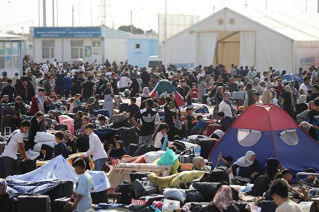 지난 7월26일(현지시각) 이란에서 돌아온 아프가니스탄 난민들이 이란과 국경을 맞대고 있는 아프가니스탄 서부 도시 이슬람칼라에서 신원 등록을 하고 있다. 이슬람칼라/EPA 연합뉴스