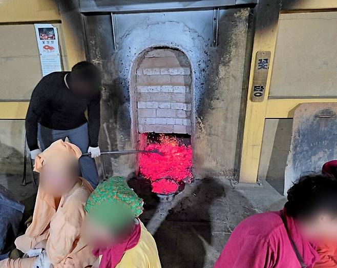 28일 오전 경기 양주시의 한 찜질방에서 직원이 가마에서 달궈진 숯을 옮기고 있다. 해당 업장은 전날 폭발 사고가 발생한 찜질방과 다르게 LPG 가스가 아닌, 숯을 활용해 장작을 달구는 방식으로 운영되고 있다. 송상호기자