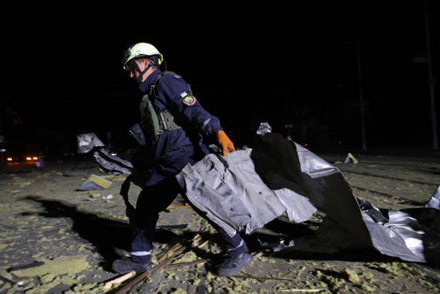 27일 러시아 드론 공격으로 우크라이나 자포리자 소재 슈퍼마켓이 피해를 입은 가운데 구조대원이 잔해를 치우고 있다. AP 연합뉴스