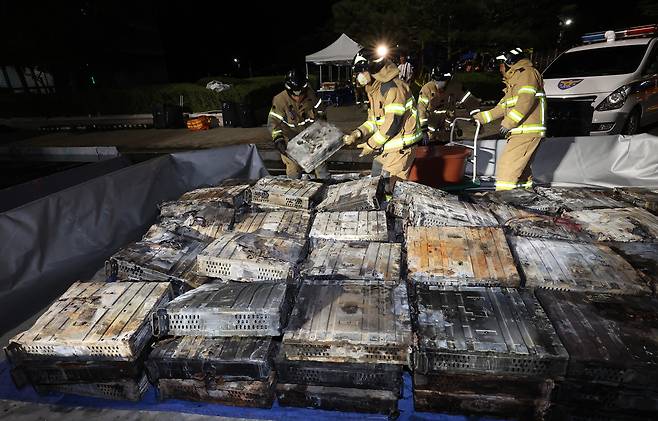 27일 밤 대전 유성구 국가정보자원관리원 화재 현장에서 소방대원들이 불에 탄 리튬이온 배터리를 소화수조로 옮기고 있다.