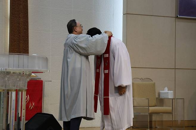 윤성원(왼쪽) 삼성제일교회 목사가 지난달 서울 강남구 교회에서 열린 사역계승예배에서 후임 유대영 목사에게 스톨을 걸어주고 있다. 삼성제일교회 제공