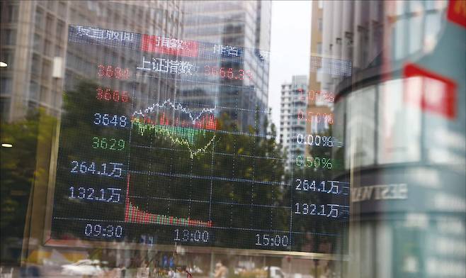 중국 베이징 증권거래소 배경에 경제 데이터가 표시된 모습. (EPA=연합뉴스)