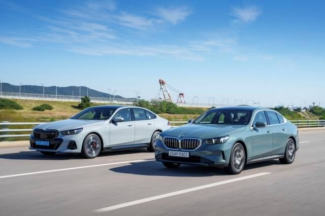 BMW 중형 세단 5시리즈 전동화 모델(왼쪽)과 내연기관 모델이 도로를 달리고 있다. [BMW 코리아 제공]