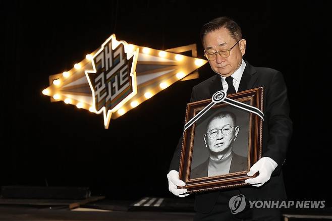 개그맨 전유성 마지막 무대 (서울=연합뉴스) 강민지 기자 = 개그맨  이홍렬이 28일 서울 영등포구 여의도 KBS 신관 '개그콘서트' 녹화 스튜디오에서 엄수된 개그맨 전유성 노제에서 영정을 운구하고 있다. 2025.9.28 mjkang@yna.co.kr