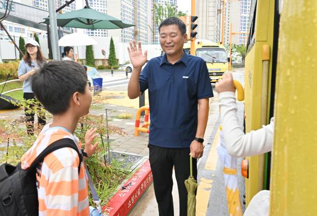 광주시 광산구 선운지구 아파트 단지 앞 스쿨버스 정류장에서 10시 출근제로 등굣길을 함께한 김승태씨가 지난 25일 오전 8시20분께 자녀들과  인사하고 있다.