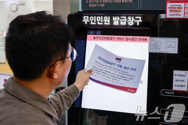 정부가 대전 국가정보자원관리원(국정자원) 전산실에서 발생한 화재로 중단된 행정정보시스템 복구에 총력을 기울이고 있는 29일 오전 서울 종로구청에서 이용이 중단됐던 무인민원발급기가 복구돼 직원이 안내문을 뗴어내고 있다. 2025.9.29/뉴스1 ⓒ News1 안은나 기자