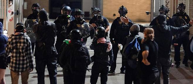 10일 미국 오리건주 포틀랜드에서 도널드 트럼프 2기 행정부의 반이민 정책에 반대하는 시위에 참여한 시민들이 무장한 이민세관단속국(ICE) 요원들과 대치하고 있다. 트럼프 대통령은 27일 포틀랜드의 치안 유지 등을 이유로 군대를 전격 투입했다. 포틀랜드=AP 뉴시스