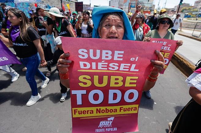 28일(현지시각) 에콰도르 수도 키토에서 사람들이 시위 도중 ‘디젤값이 오르면, 모든 것이 오른다. 노보아(대통령) 물러가라, 물러가라’라는 내용이 적힌 손팻말을 들고 있는 모습. 이날 진행된 낙태 합법화 지지 시위에 원주민 시위대가 합류했다. EPA 연합뉴스