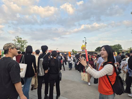 지난 27일 오후 5시쯤, '2025 서울세계불꽃축제' 봉사활동에 참여한 정부경(25)씨가 경광봉을 흔들며 시민들을 안내하고 있다. 전율 기자