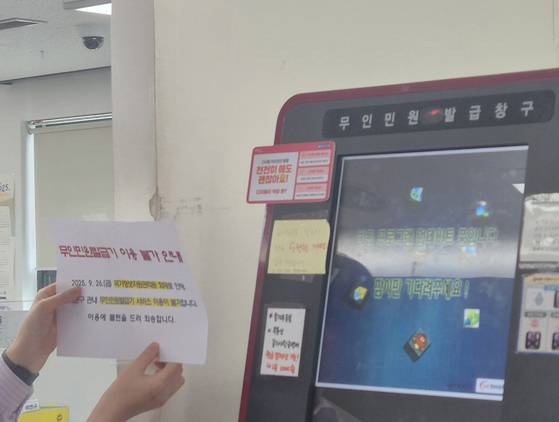 29일 오전 9시 20분쯤, 서울 동대문구 한 주민센터 직원이 무인민원발급기 앞에 '이용 불가'를 알리는 안내문을 붙이고 있다. 전율 기자
