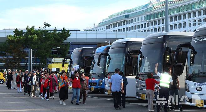 [인천=뉴시스] 전진환 기자 = 중국인 단체관광객에 대한 무비자 입국 시행 첫날인 29일 오전 인천 연수구 인천항 크루즈터미널에서 중국인 단체 크루즈 관광객이 입국해 버스로 향하고 있다.  2025.09.29. amin2@newsis.com