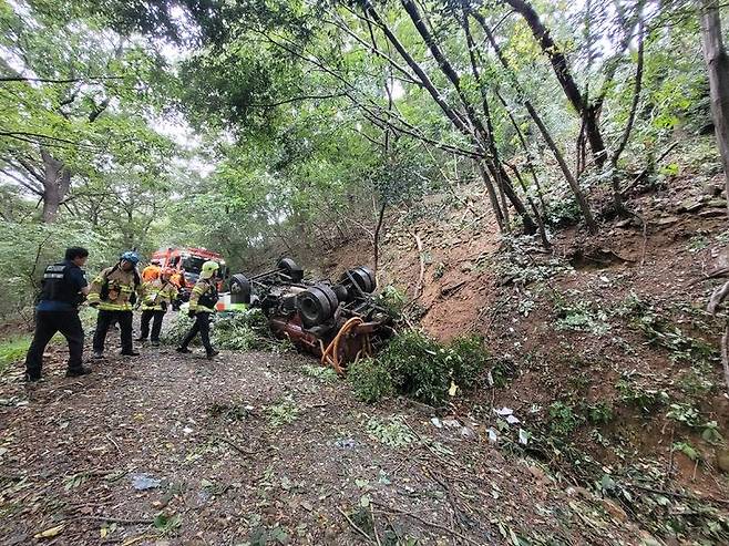 [양산=뉴시스] 양산시 호계동 천성산의 한 임도를 내려오던 4t급 분뇨 수거차가 약 70m 아래로 추락, 경찰과 119 구조대가 구조하고 있다. (사진=독자 제공) 2025.09.29. photo@newsis.com *재판매 및 DB 금지