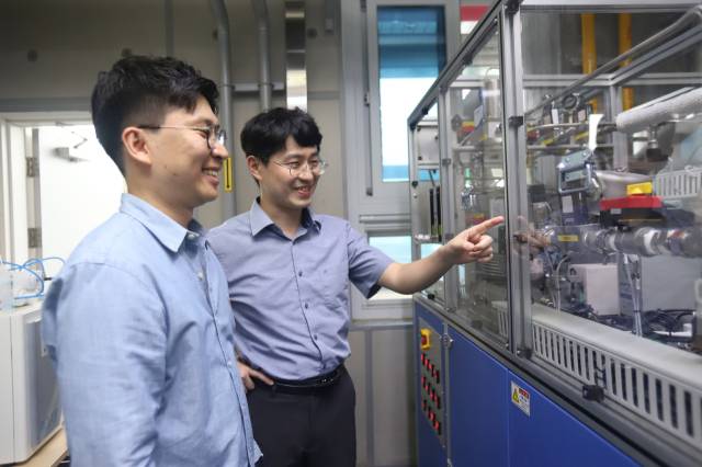 한국기계연구원 무탄소발전연구실 김영상(오른쪽) 책임연구원이 배용균(왼쪽) 선임연구원과 함께 20kW급 연료극지지형 고체산화물 수전해 시스템을 살펴보고 있다. 사진제공=한국기계연구원