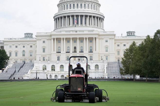 미국 워싱턴 D.C. 국회 의사당 앞마당에서 한 노동자가 잔디를 깎고 있다. (사진=AFP)
