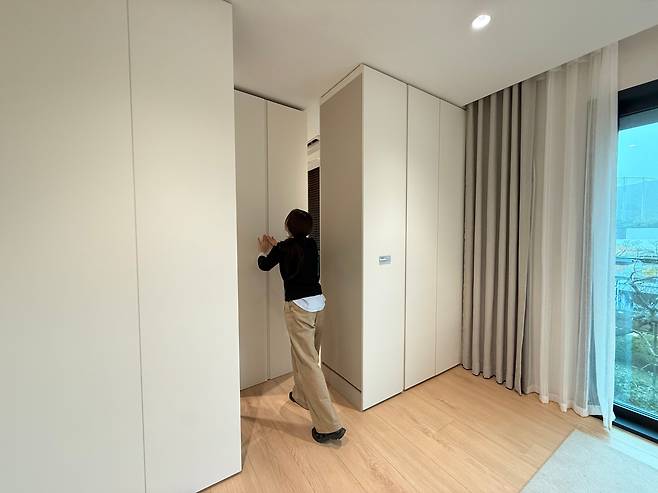 경기도 용인시에 있는 삼성물산의 넥스트홈(Next Home)에서 거실과 드레스룸 사이에 놓인 이동식 붙박이장을 손으로 밀어 공간을 넓히고 있다. /김휘원 기자