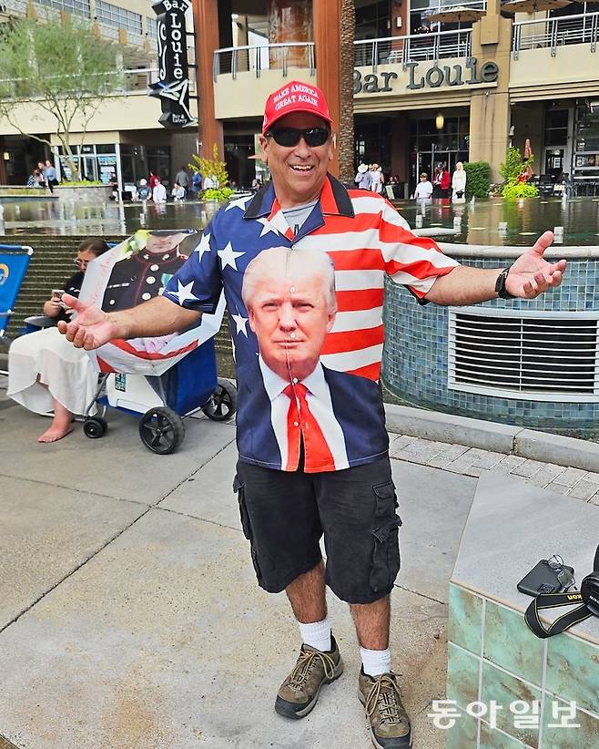 지난달 21일(현지 시간) 미국 애리조나주 글렌데일 스테이트팜 스타디움에서 열린 찰리 커크 터닝포인트USA 대표 추모식에서 ‘트럼프 티셔츠’를 입은 참석자가 포즈를 취하고 있다. 붉은색 마가 모자를 쓴 그는 “오늘은 미국을 수호하는 사람들이 모인 날”이라고 했다. 글렌데일=신진우 특파원 niceshin@donga.com