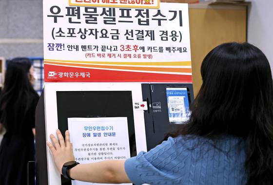 우체국도 혼선. 29일 오전 서울 종로구 광화문우체국에서 직원이 무인우편접수기에 국가정보자원관리원 화재로 인한 장애 발생 안내문을 붙이고 있다. [뉴스1]