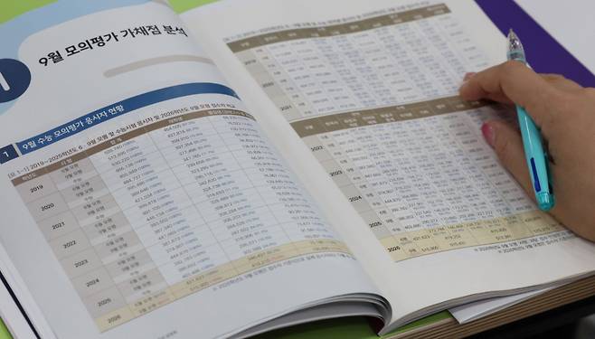 [서울=뉴시스] 권창회 기자 = 6일 서울 강남구 강남하이퍼학원 본원에서 열린 '9월 모의평가 분석설명회에서 학부모들이 9월 모평 분석집을 살펴보고 있다.