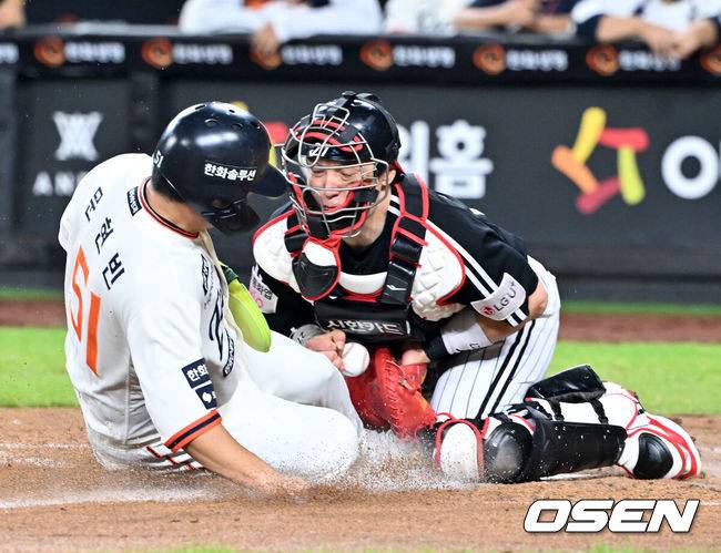 [OSEN=대전, 민경훈 기자] 29일 오후 대전 한화생명볼파크에서 2025 신한 SOL Bank KBO리그&nbsp;한화 이글스와&nbsp;LG 트윈스의 경기가 열렸다.한화는&nbsp;정우주, LG는&nbsp;임찬규를 선발 투수로 내세웠다.3회말 2사 주자 2루 한화 노시환의 좌익수 앞 안타때 한화 문현빈이 홈으로 몸을 날렸다. LG 포수 박동원이 좌익수 문성주의 홈 송구를 놓치는 포구 실책을 범하면서 한화 문현빈의 득점이 인정됐다.  2025.09.29 /rumi@osen.co.kr