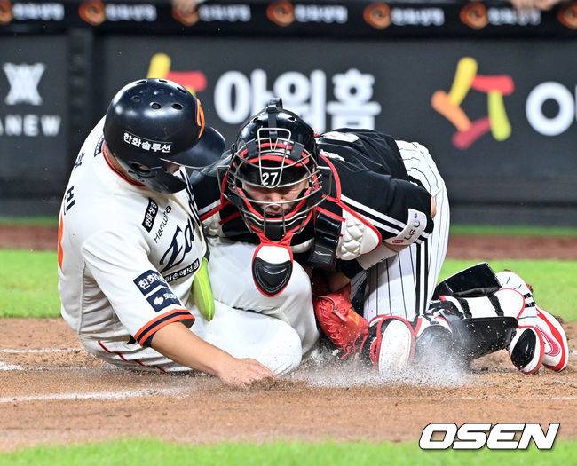 [OSEN=대전, 민경훈 기자] 29일 오후 대전 한화생명볼파크에서 2025 신한 SOL Bank KBO리그 한화 이글스와 LG 트윈스의 경기가 열렸다.한화는 정우주, LG는 임찬규를 선발 투수로 내세웠다.3회말 2사 주자 2루 한화 노시환의 좌익수 앞 안타때 한화 문현빈이 홈으로 몸을 날렸다. LG 포수 박동원이 좌익수 문성주의 홈 송구를 놓치는 포구 실책을 범하면서 한화 문현빈의 득점이 인정됐다.  2025.09.29 /rumi@osen.co.kr