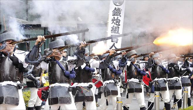 일본 전국시대, 신형 무기인 화승총은 오랜 균형 상태를 부수는 ‘돌연변이’ 무기였다. 오다 노부나가는 판세를 바꿀 무기인 화승총에 막대한 투자를 감행, 마침내 역사의 승자로 올라섰다. 사진은 일본 전통문화 행사에서 에도시대 사무라이 복장을 한 재현단이 화승총 사격 시범을 보이는 모습. (AFP=연합뉴스)