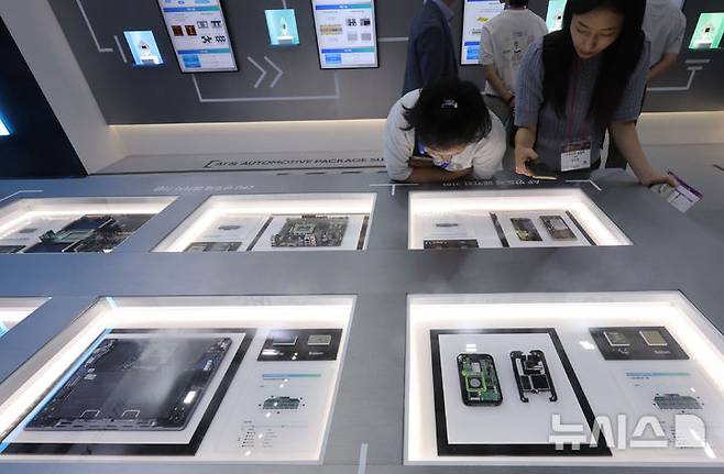 [인천=뉴시스] 전진환 기자 = 4일 오전 인천 연수구 송도컨벤시아에서 열린 '제22회 국제 첨단 반도체 기판 및 패키징 산업전'을 찾은 관람객들이 삼성전기 부스에서 반도체 패키지 기판을 살펴보고 있다. 2025.09.04. amin2@newsis.com