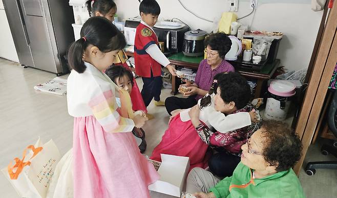 울릉초등학교병설유치원 어린이들이 추석을 앞두고 경로당을 방문해 할머니들에게 선물을 드리고 있다./울릉교육지원청 제공