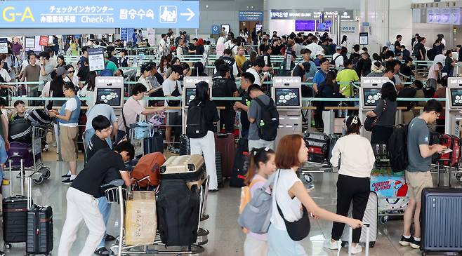 Travelers crowded Incheon International Airport on Aug. 8. [YONHAP]