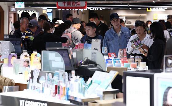 Chinese tourists shop at the Shilla Duty Free shop in central Seoul on Sept. 29, the day visa-free entry for Chinese group tourists began. [NEWS1]